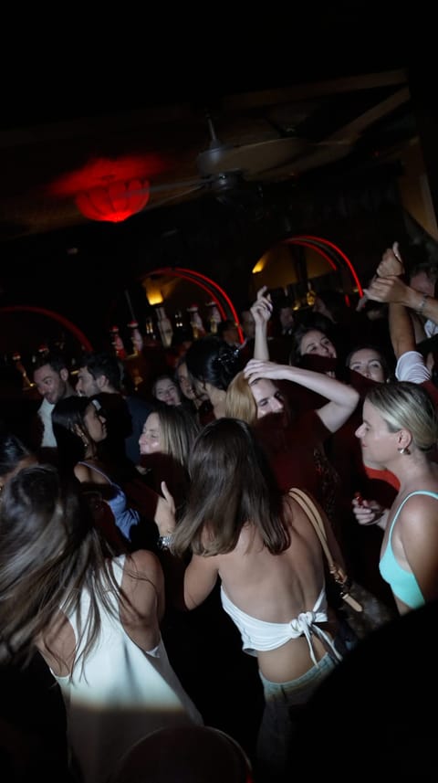 Guests dancing under the red-lit arches at Club 55