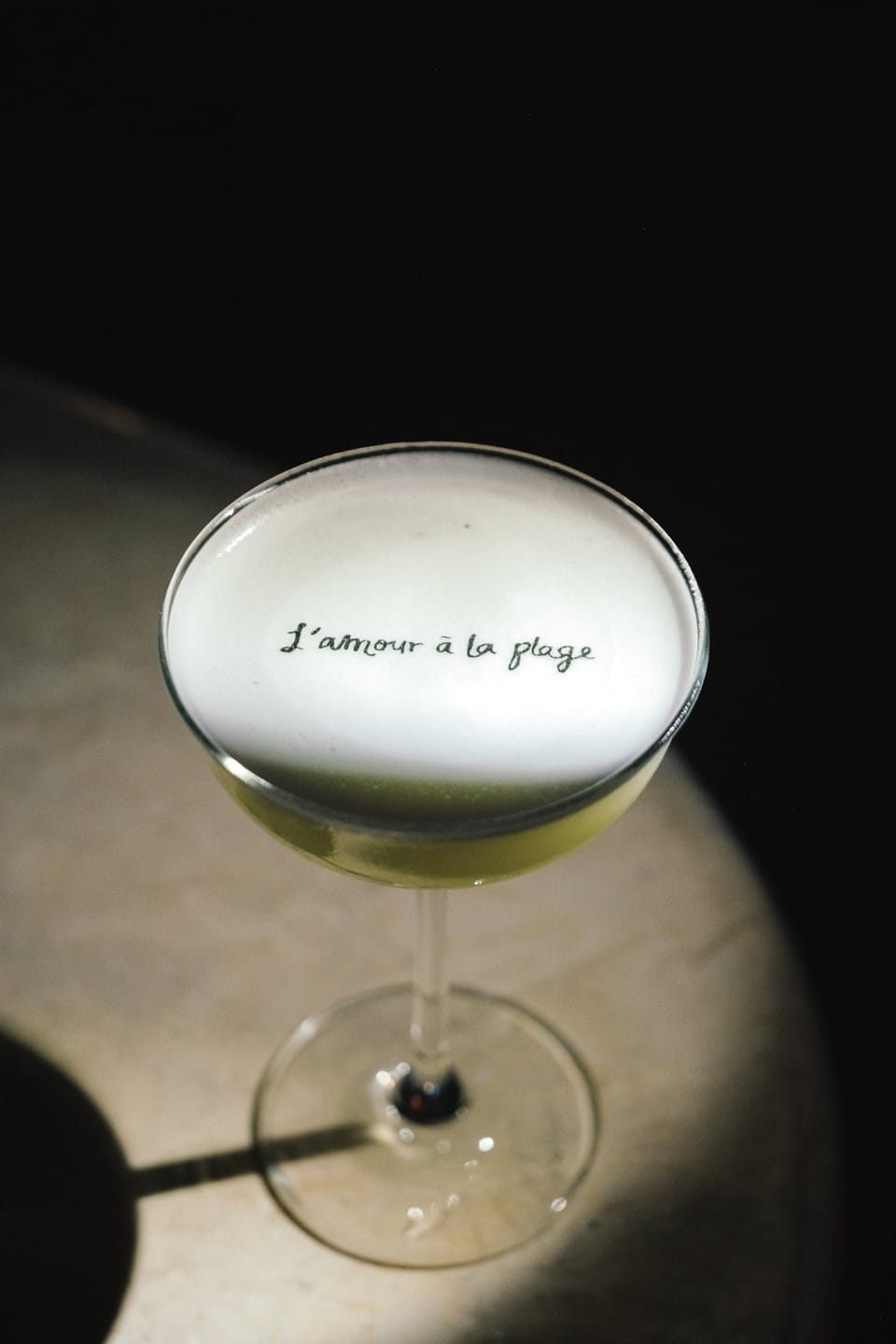 A cocktail with L'amour à la plage written on the foam
