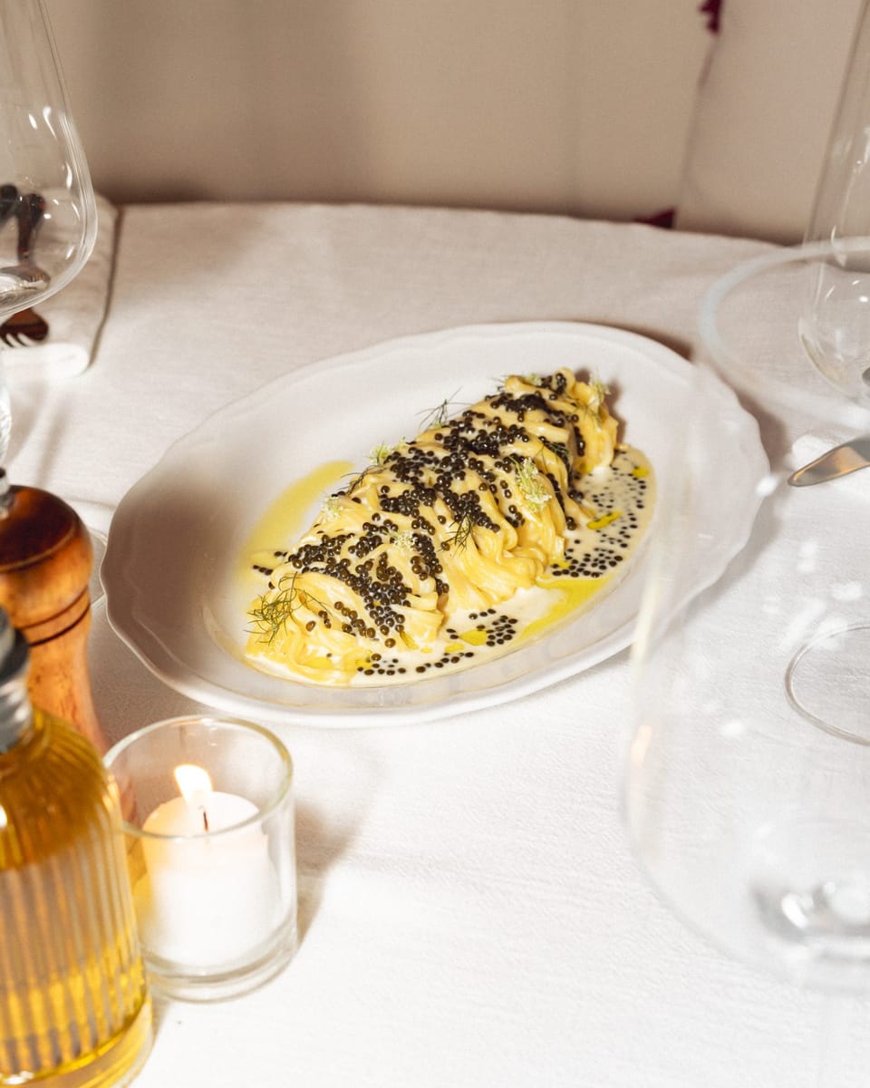 Truffle tortellini on a white plate by candlelight