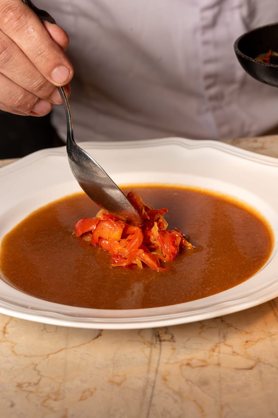Tomatoes spooned onto the sauce
